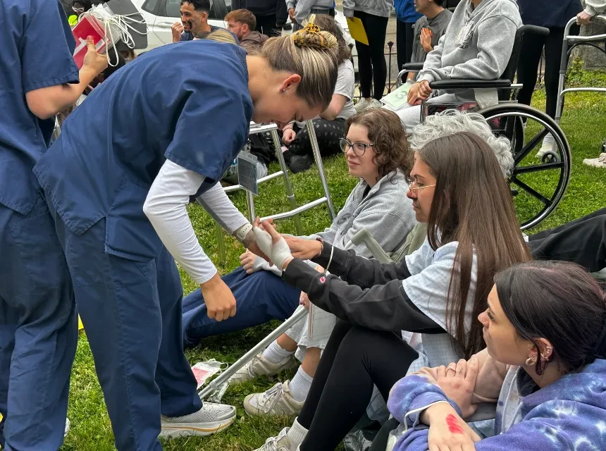 Nursing students treat a "patient" at a simulated disaster event on campus. 