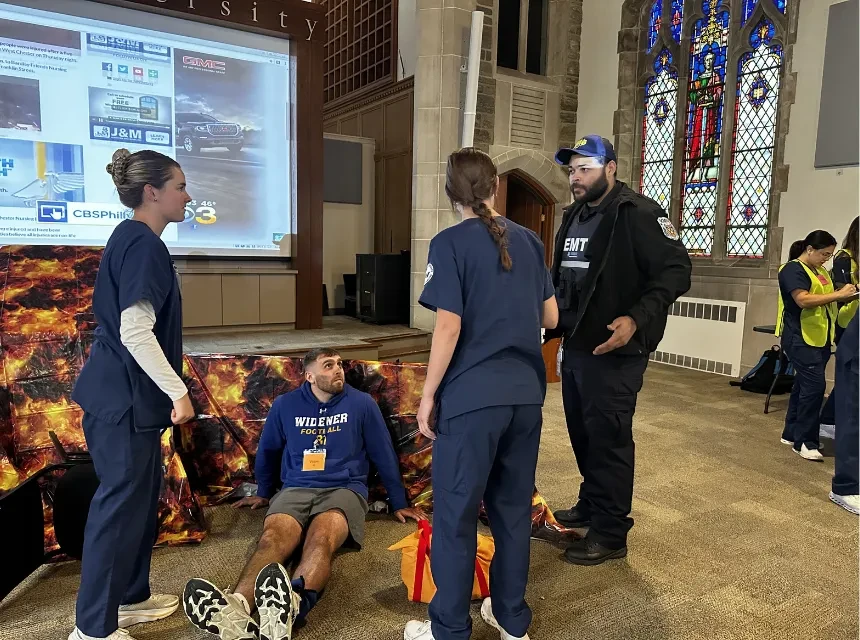 Nursing students treat a "patient" at a simulated disaster event on campus. 