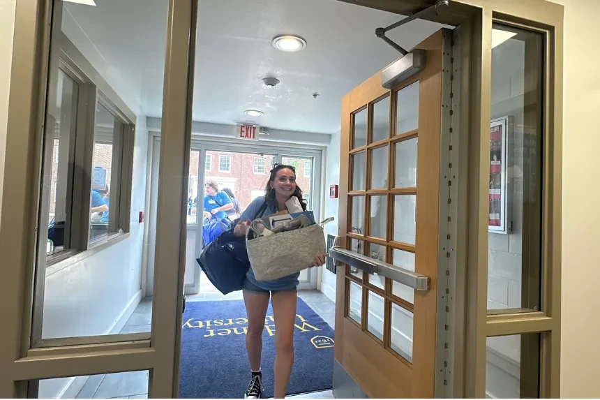 Student volunteers help new students carry belongings into residence halls at move in.