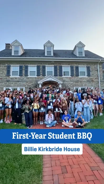 Large group of students pose for a photo with President Robertson in front of the Billie Kirkbride House