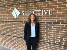 Emily Garofalo stands in front of the Selective Insurance sign.