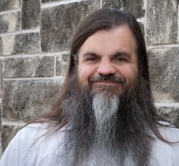 Headshot of Bryan Alexander in front of stone wall