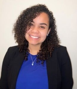 Headshot photo of Taziah Kenney in black blazer and blue shirt