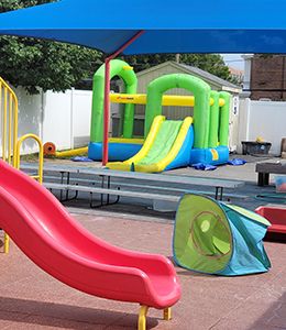 Outdoor play equipment, including a slide and inflatable house, at Child Development Center