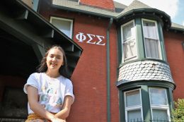Briana Dilger sits on the porch of the Phi Sigma Sigma sorority house.
