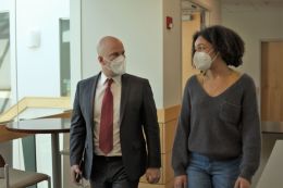 A business professor and female undergrad walk in the hallway of the business school.