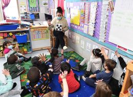 Student working with young children in a classroom