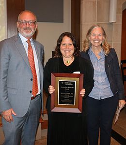 Shana Maier with award plaque standing alongside provost and president