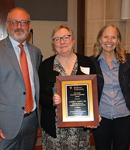 Andrea Martin with award plaque standing alongside provost and president