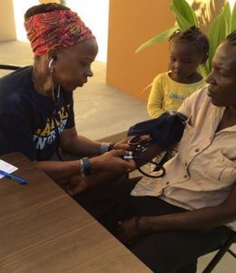 Rhonda Hazell checks the pulse of a female patient in a clinic in Haiti.