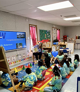 President Stacey Robertson reading to students of the CDC