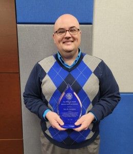 Eric Kniskern holding his Wollman Award trophy