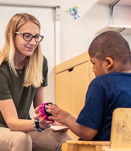 instructor works with a student in a special education classroom