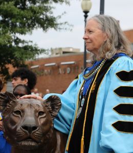 President Robertson in regalia touching the Pride of Lions statue