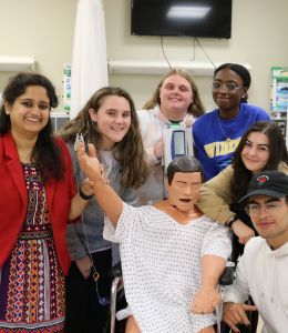 Ria Mazumder poses with biomedical engineering students in the nursing sim lab