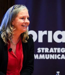 Stacey Robertson speaking with brian communications banner behind her