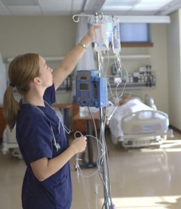 Female nursing student prepares an IV bag in the simulation lab.