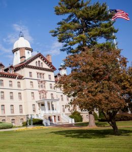 The front of Old Main displays the flag pole on a beautiful day.