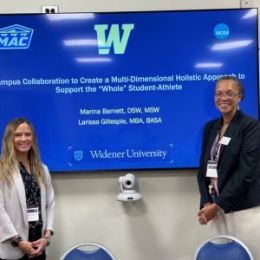 Larissa Gillsepie and Marina Barnett standing by the screen with their presentation slide