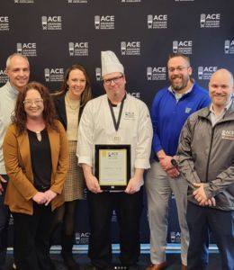 Chef Matt smiles with his 1st place trophy alongside Widener staff.