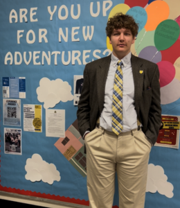 George Hebda poses for a photo wearing a suit