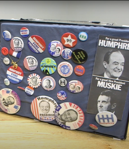 A frame with a collection of buttons and stickers from past presidential elections