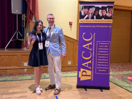 Joana Rodriguez standing with Ryan Mignone holding her award