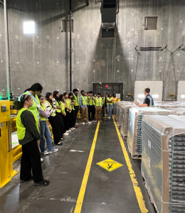 high school students take a tour of a factory
