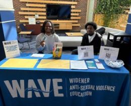 Two student volunteers sitting at a Widener Anti-Sexual Violence Education table