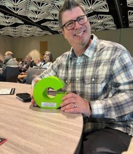 Chef Matt smiling with a green G-shaped trophy