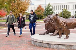 Students walking past Pride statues on Widener Campus