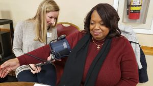 Student reads blood pressure of woman