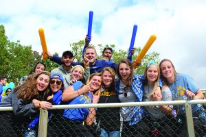 group of student cheering at homecoming football game