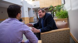 Business professor meeting with student in lobby of Quick Center