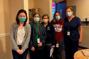 Cathy Evans, Gretchen Bernatowicz, Nancy Hesse pose with colleagues while serving on a mission at the Liacouras Center.