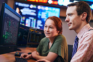 Two finance students in investment lab working on a computer