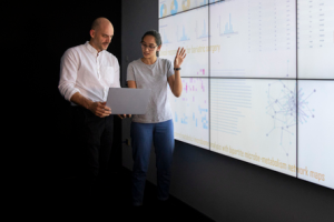 Nurse researchers 300x200 Two health care professionals presenting research in front of a large projection screen
