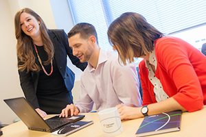 Three business professionals at a conference table in a meeting
