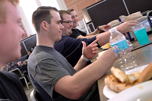 Group of sudents sitting in Pride Cafe eating pizza