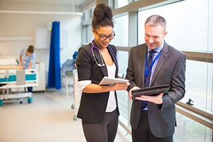 Two health care professionals looking at patient charts in a hospital setting