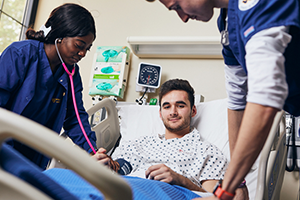 Two Widener nursing students working on a patient in a clinical setting
