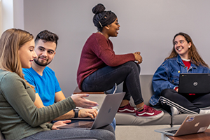 Students in living learning community 300x200 Students sitting in a lounge area on computers