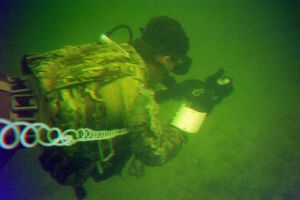 Underwater photo of ROTC cadet in camouflage with gear and breathing cord 