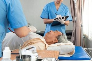 Two acute care nurses caring for a patient on a hospital bed