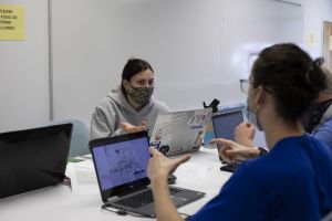 Female and male civil engineering students converse during a team project meeting.