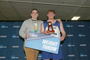 Coach Alex Palescandolo and athlete Alex Kristeller on the podium after NCAA win