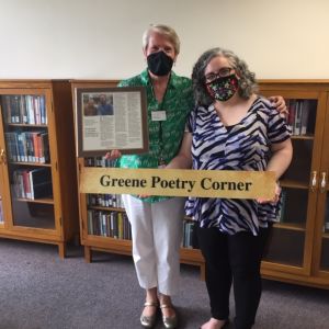Deb Morley and Jessica Guzman pose with the Greene Poetry Room sign.