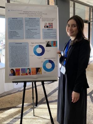 Widener alumna Brenna Hagan stands next to her poster presentation