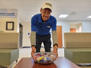 ABM employee Stan Price placing bowl of candy on a table