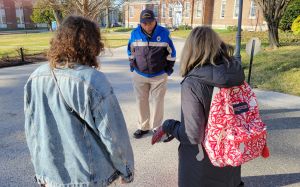 Officer Norman Mitchell talking with two people who have their backs to the camera.